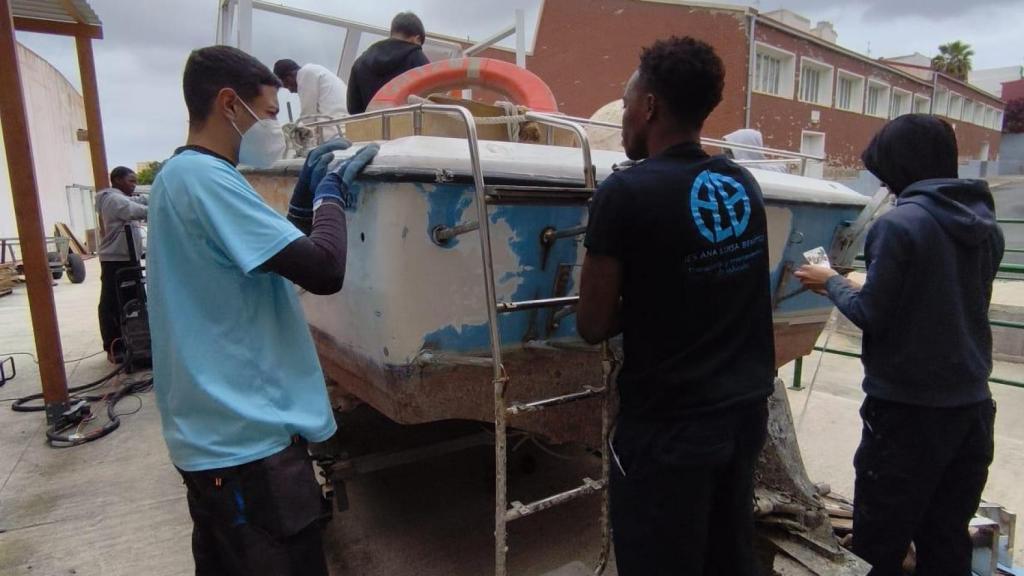 Alumnos trabajando en la reparación del barco.