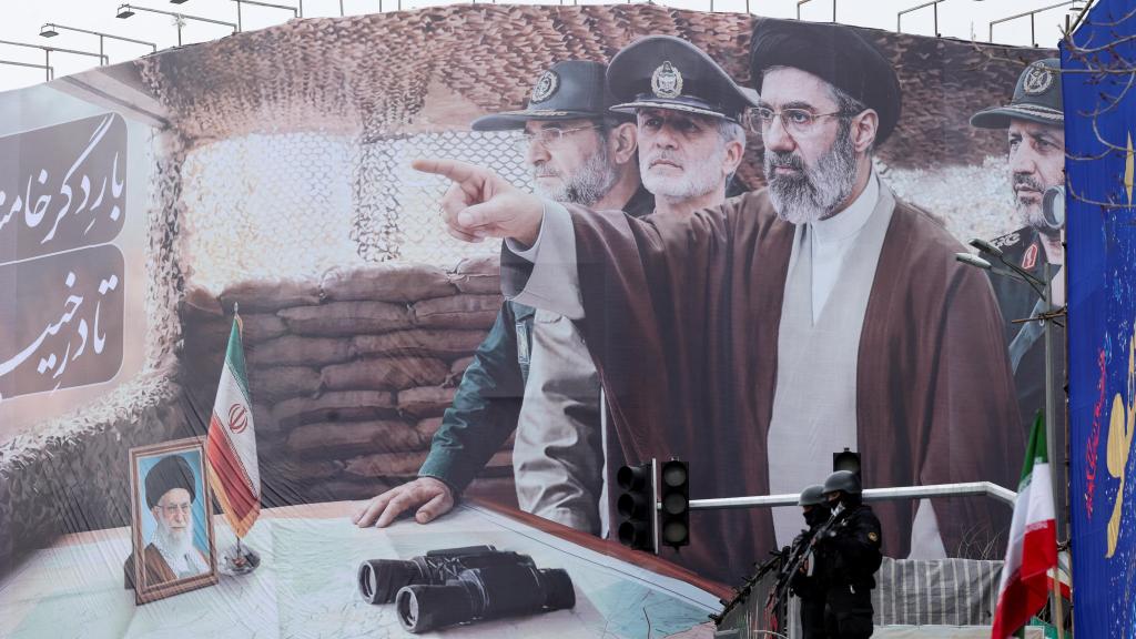 Agentes armados montan guardia en Teherán frente a una pancarta que rinde homenaje al nuevo líder supremo, Mojtaba Jamenei, y a su padre Alí.