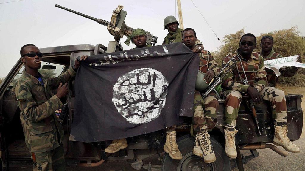 Soldados nigerianos alzan una bandera de Boko Haram que habían confiscado en la ciudad de Damasak, Nigeria, recientemente recuperada, el 18 de marzo de 2015.