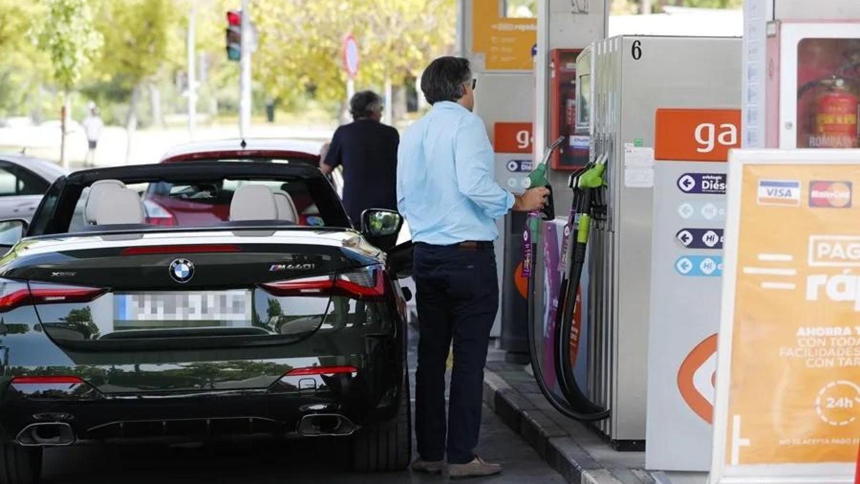 Unas personas repostan combustible en una gasolinera de Madrid.