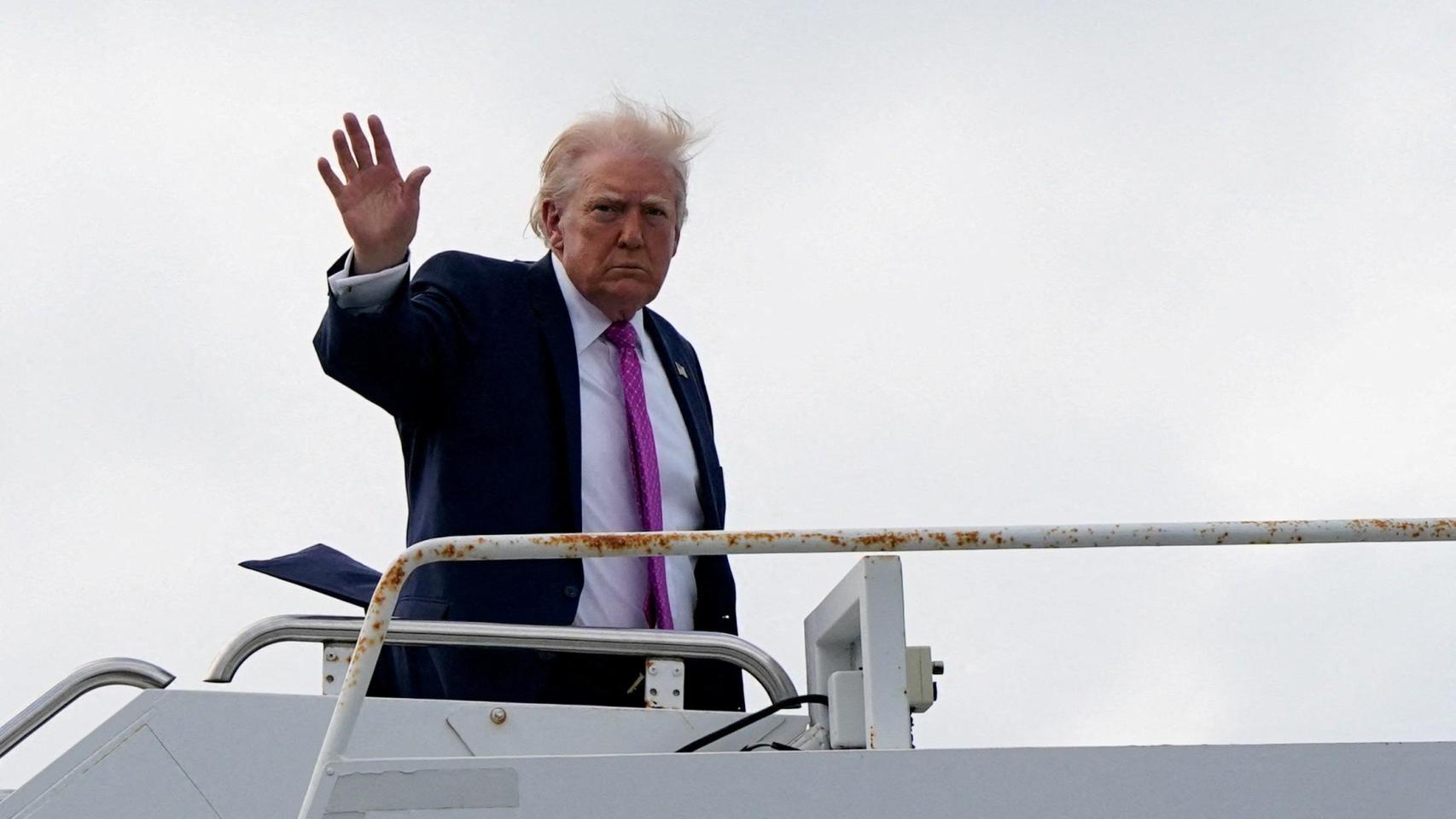 Trump saluda desde el Air Force One en el aeropuerto de Palm Beach.