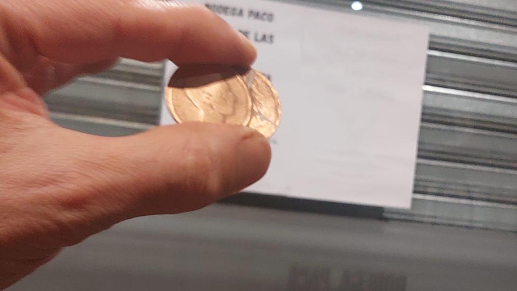 El baratero muestra las chapas delante de Bodega Paco