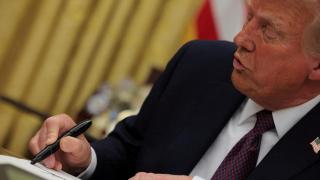 Donald Trump firmando una orden ejecutiva en el Despacho Oval.
