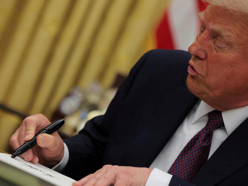 Donald Trump firmando una orden ejecutiva en el Despacho Oval.