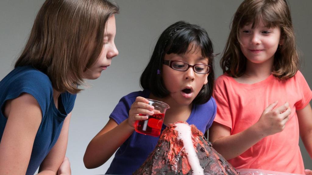 Un grupo de niños realizando un experimento de un volcán.