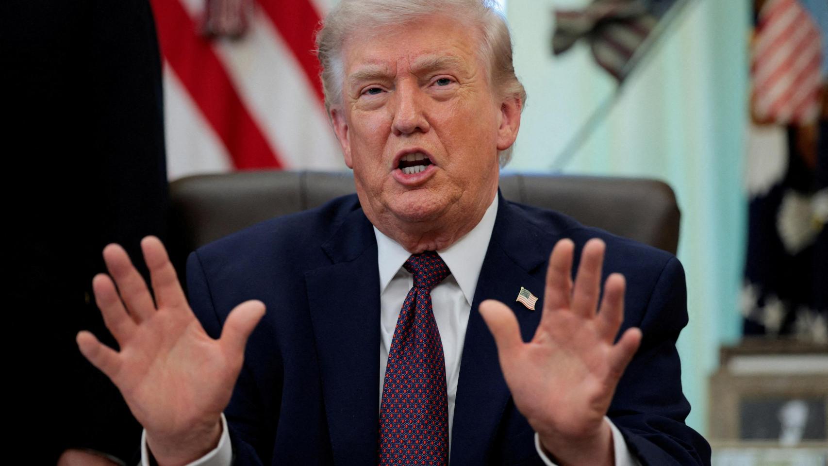 Donald Trump gesticula mientras habla con la prensa en el Despacho Oval.