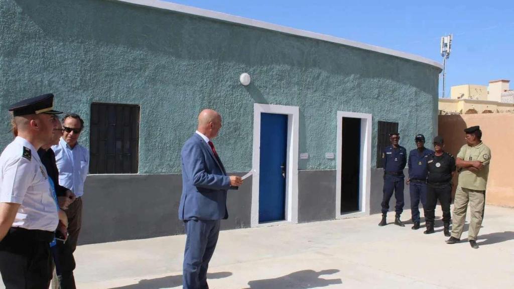 Un agente de la Policía Nacional española (izquierda, camisa blanca), con uniforme de gala, durante la inauguración del centro de retención de migrantes en Nuadibú, uno de los dos recintos financiados por la UE y ejecutados con participación española en Mauritania.