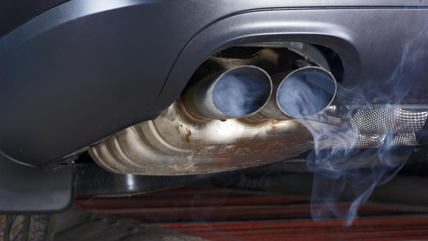 Tubo de escape de un coche soltando la contaminación.