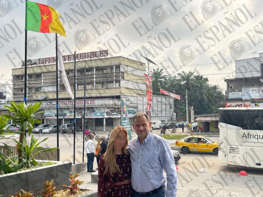 José Luis Ábalos y Andrea de la Torre, posan frente a la bandera de Camerún en una calle de Douala.
