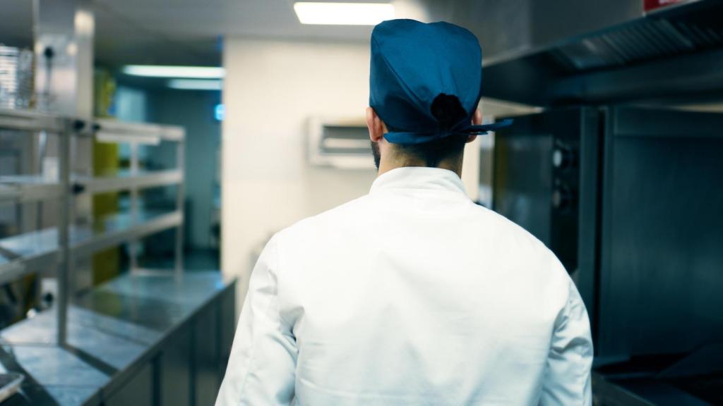 Un cocinero de espaldas en una cocina.