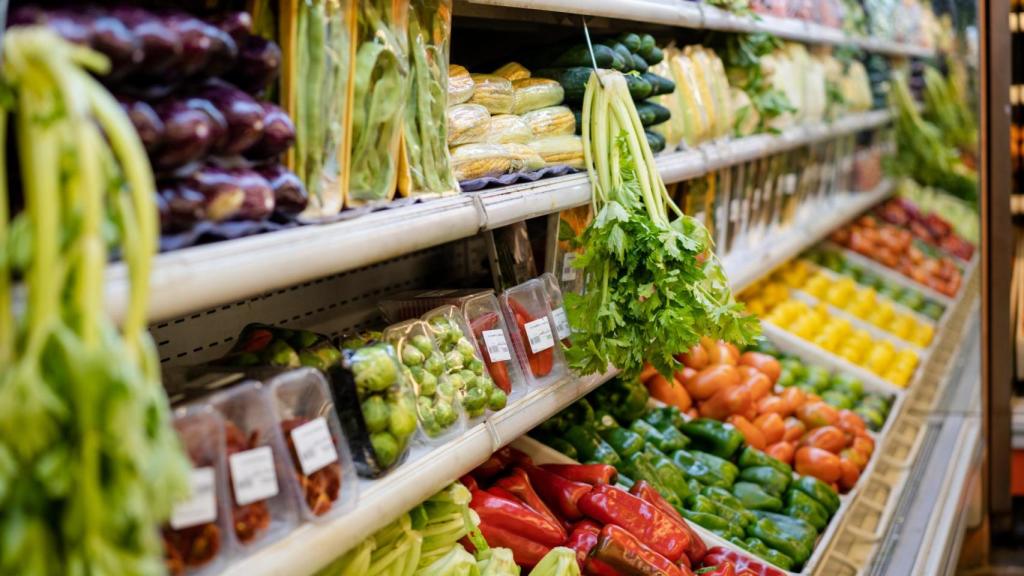 Unos lineales de frutas y verduras en un supermercado.