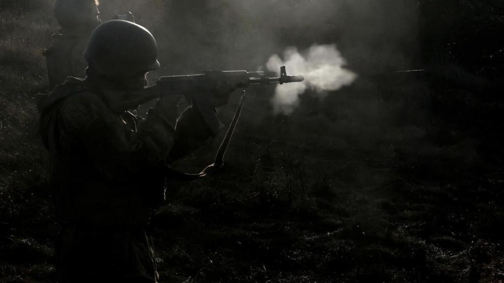 A soldier fires a bullet from a Kalashnikov AK-74 assault rifle.
