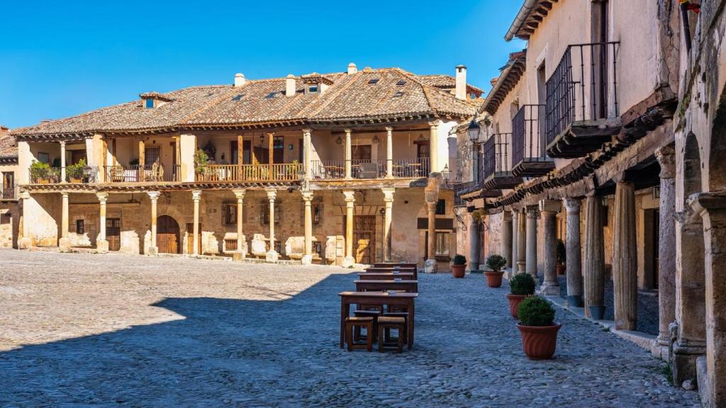 Plaza principal de la ciudad de Pedraza con sus edificios medievales sostenidos por columnas y balcones de madera, Segovia, España