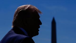 Donald Trump habla con la prensa con el monumento a Washington de fondo.