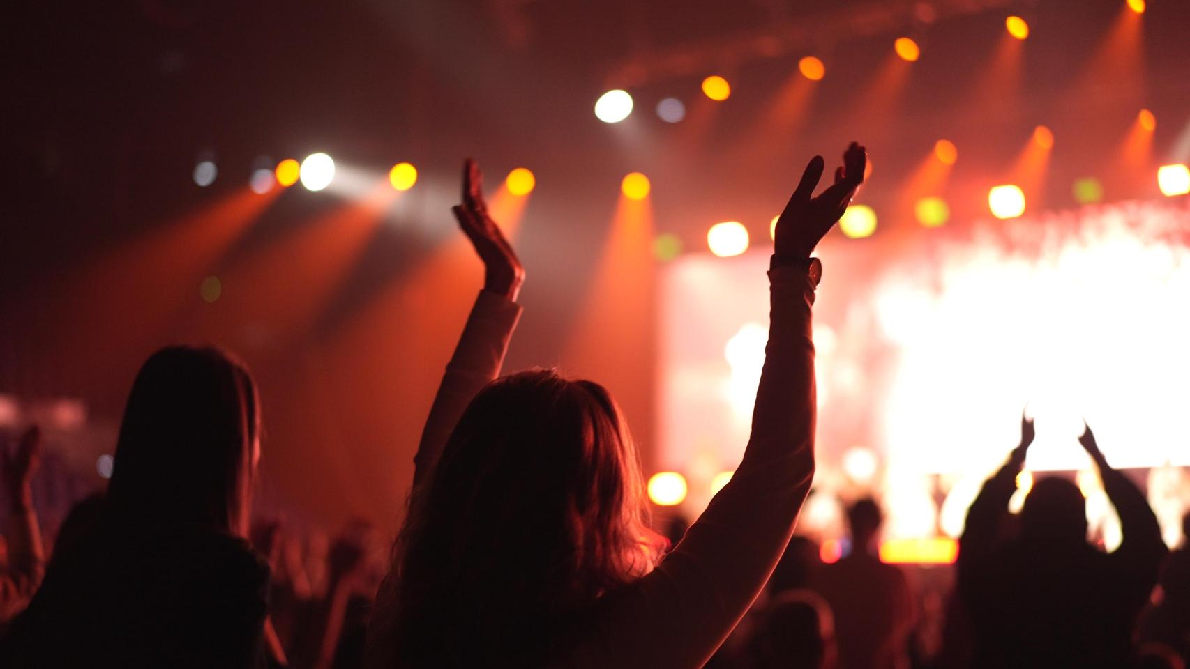 Una joven aplaude en un concierto