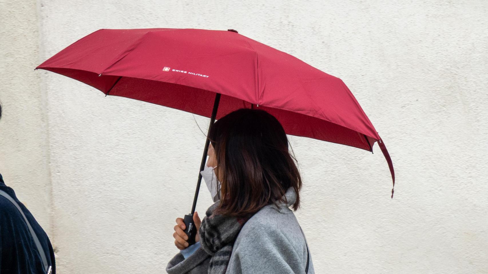 Una turista protegiéndose de la lluvia.