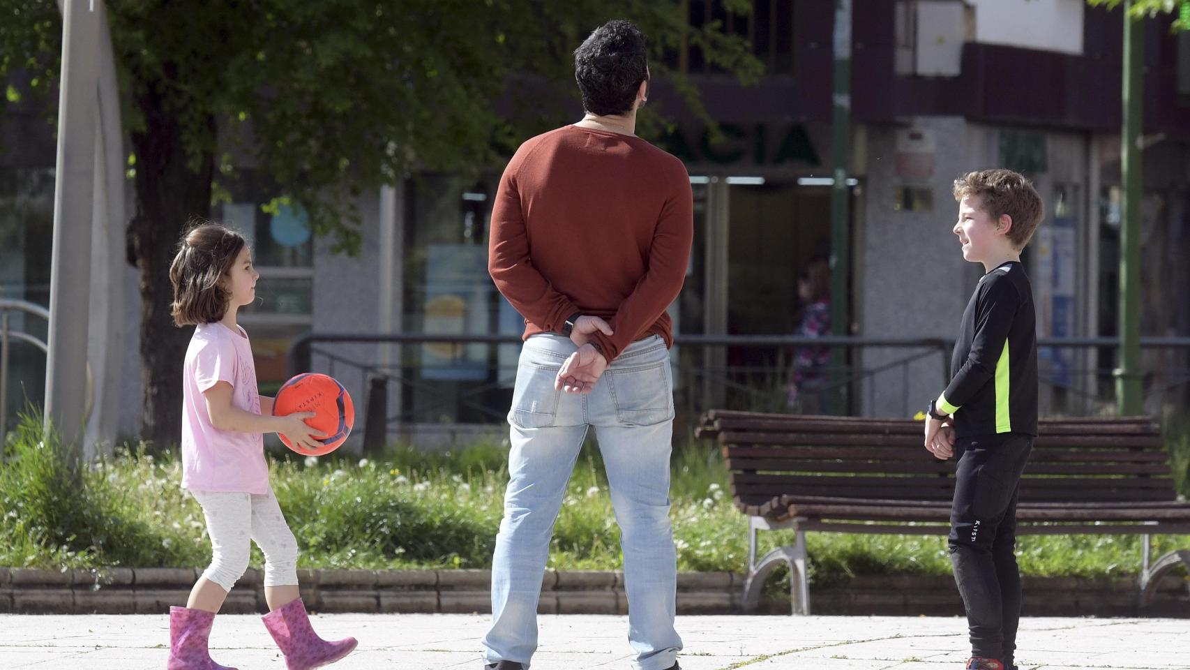 Un hombre juega con dos niños en un parque de la ciudad de Burgos, en una imagen de archivo