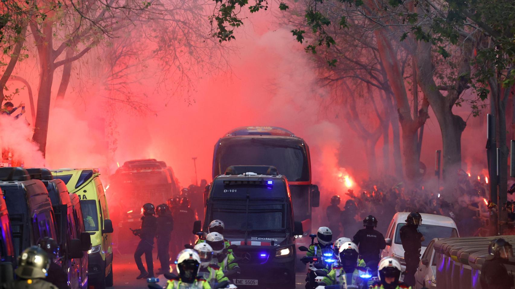 Los aficionados lanzan bengalas a la llegada del autobús del FC Barcelona.