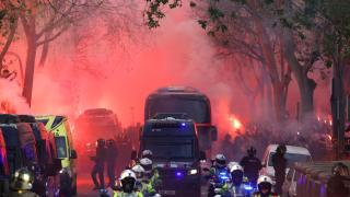 Los aficionados lanzan bengalas cuando llega el autobús del FC Barcelona.