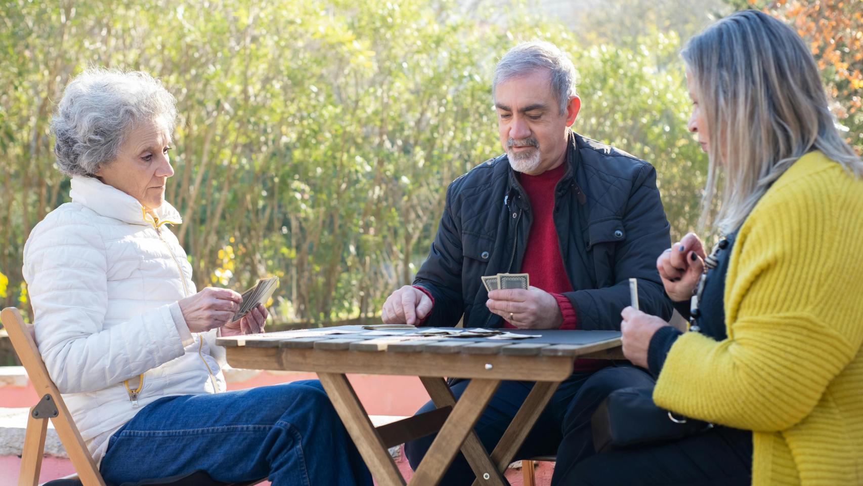 Un grupo de jubilados jugando a las cartas.