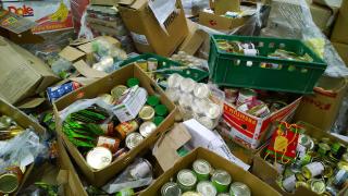 ECajas de cartón con alimentos enlatados en latas en suelo.