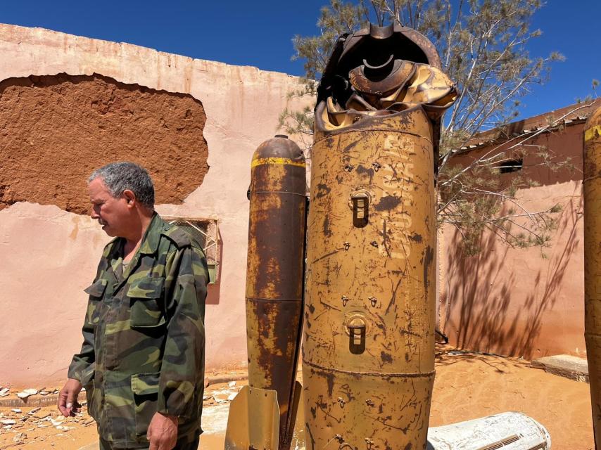 Mohamed Uleida poses next to remains of explosives.