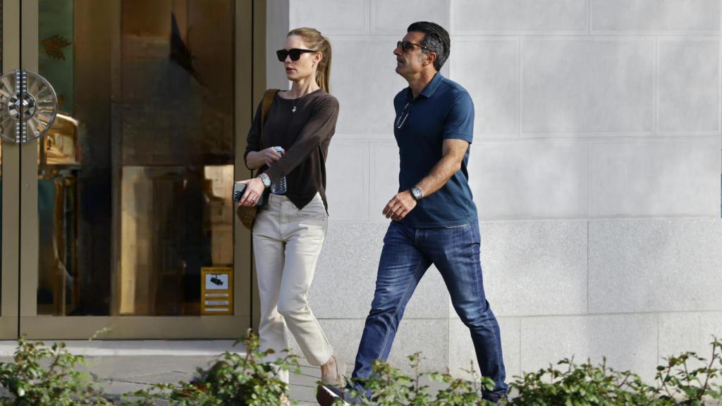 Figo y su esposa, caminando, mientras comparten confidencias.