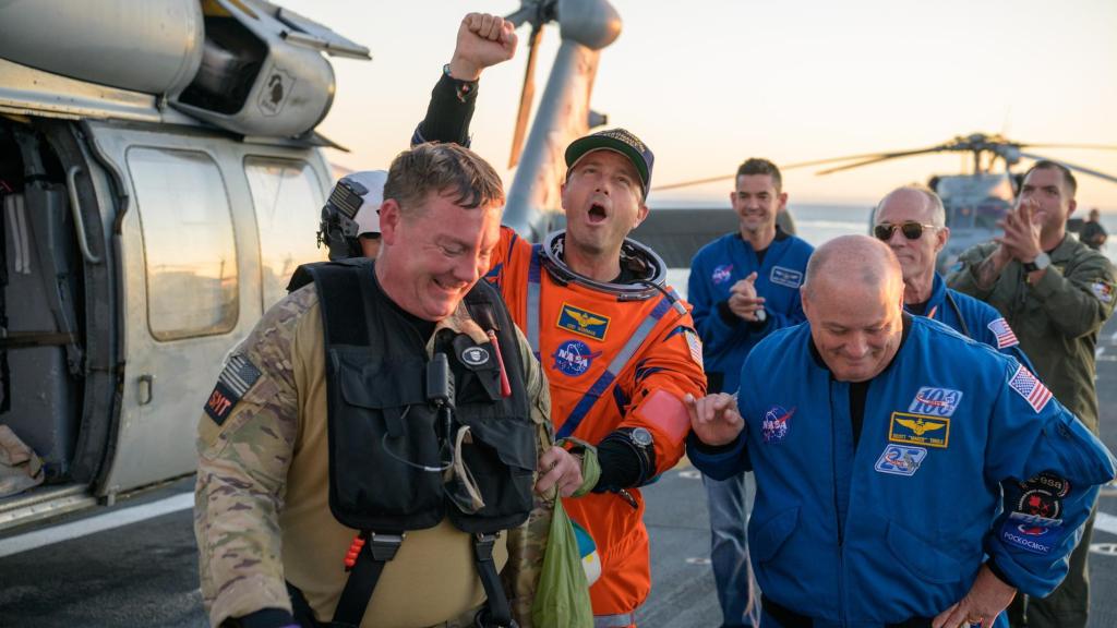 El astronauta Reid Wiseman junto a personal de la NASA y la US Navy tras aterrizar en la cubierta del USS John P. Murtha