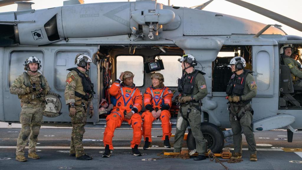 Los astronautas Victor Glover y Christina Koch, junto a personal de la US Navy, recién aterrizados en la cubierta del USS John P. Murtha