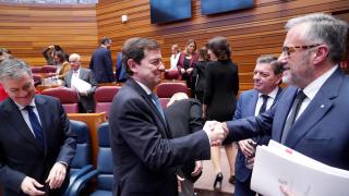 El presidente de la Junta en funciones, Alfonso Fernández Mañueco, saluda al entonces presidente de las Cortes y candidato de Vox, Carlos Pollán, en un pleno del Parlamento autonómico, en diciembre de 2025