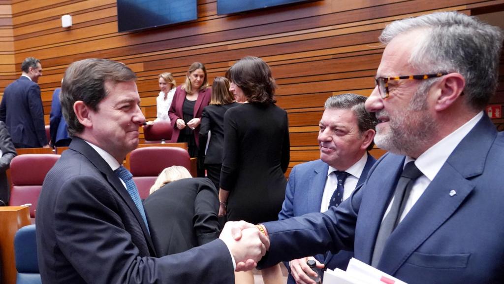 El presidente de la Junta en funciones, Alfonso Fernández Mañueco, saluda al entonces presidente de las Cortes y candidato de Vox, Carlos Pollán, en un pleno del Parlamento autonómico, en diciembre de 2025