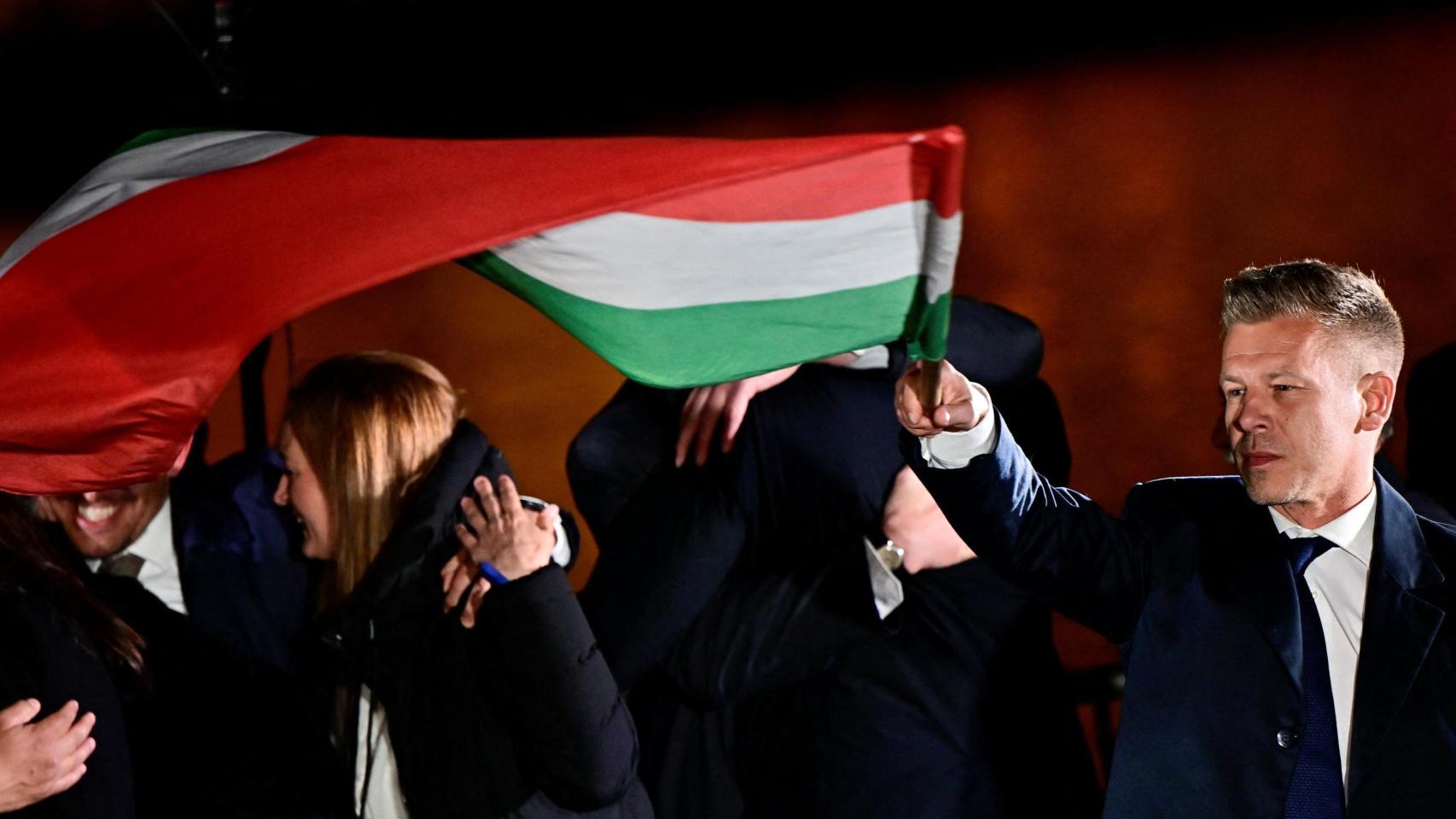 Peter Magyar, celebra la victoria electoral enarbolando la bandera húngara.