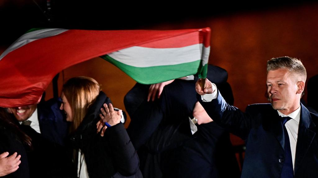 Peter Magyar, celebra la victoria electoral enarbolando la bandera húngara.