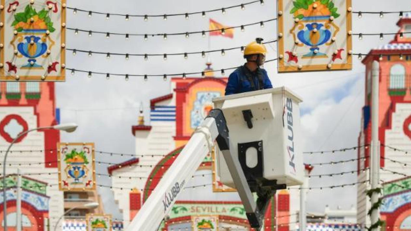 Un electricista comprobando el alumbrado en el Real de la Feria de Sevilla en 2025.