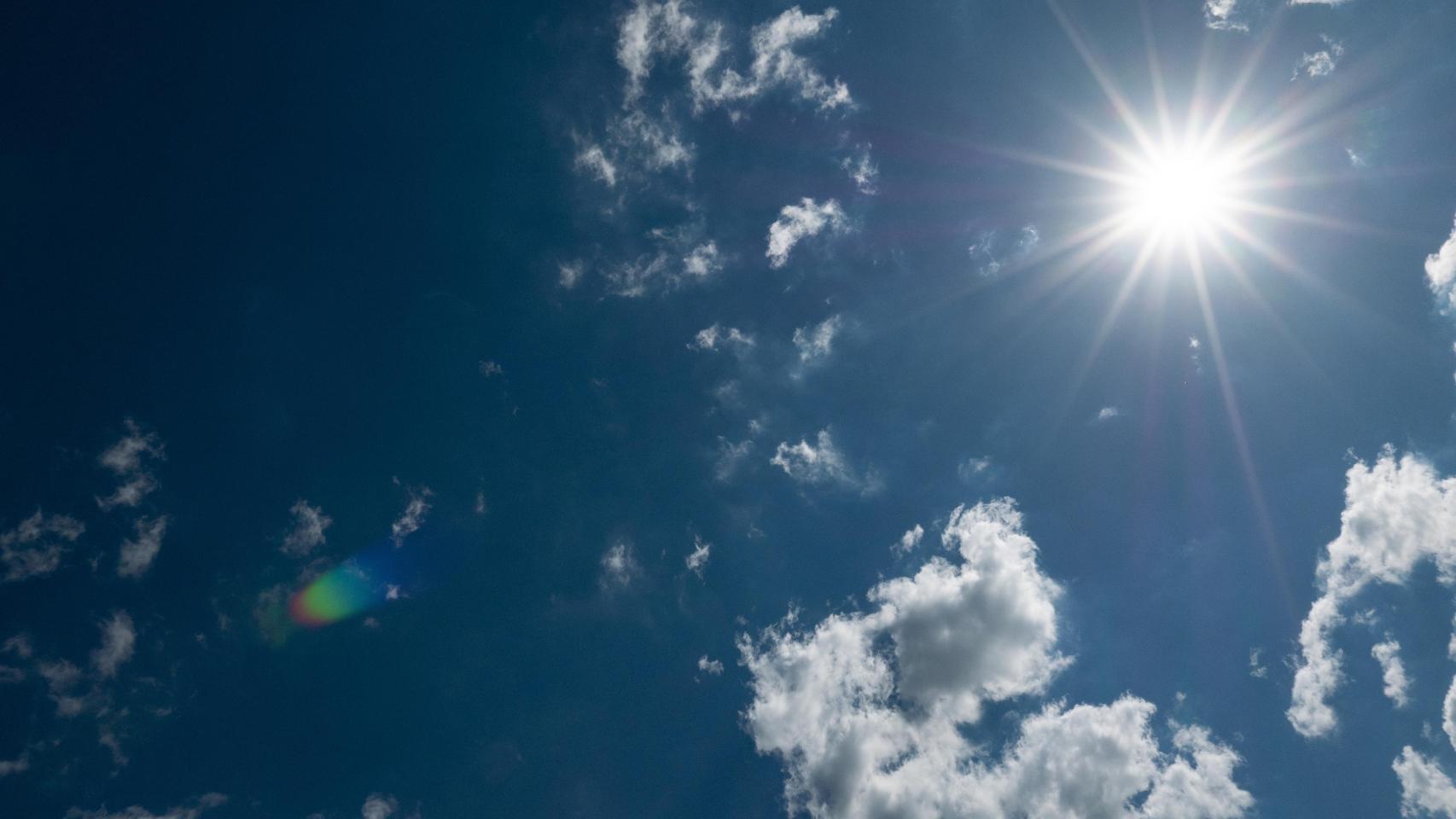 Un cielo con sol y nubes