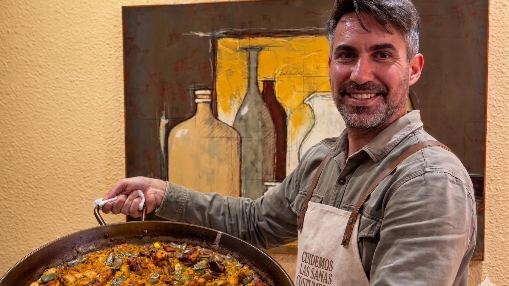 Héctor Medina, chef, junto a una paella.