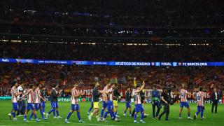 Los jugadores del Atlético rodean el campo.