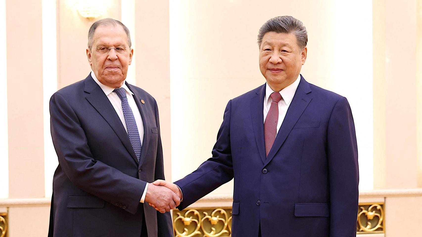 El ministro de Exteriores ruso, Serguéi Lavorv, y el presidente chino, Xi Jinping, se estrechan la mano en el edificio del Gran Salón del Pueblo.