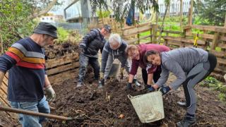 Varias personas trabajan en la huerta comunitaria de Canido, en Ferrol.
