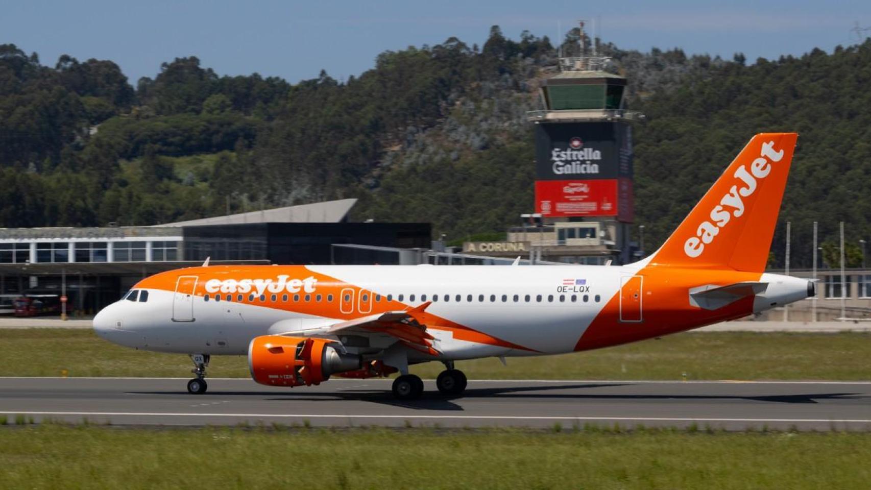 Un avión de Easyjet en la pista de Alvedro con la torre de control al fondo.