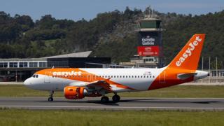 Un avión de Easyjet en la pista de Alvedro con la torre de control al fondo.