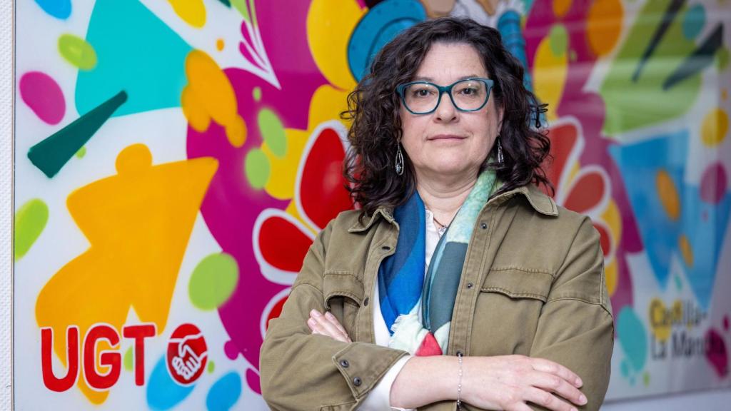Lola Alcónez posa junto a un mural instalado en la entrada a la sede de UGT Castilla-La Mancha.