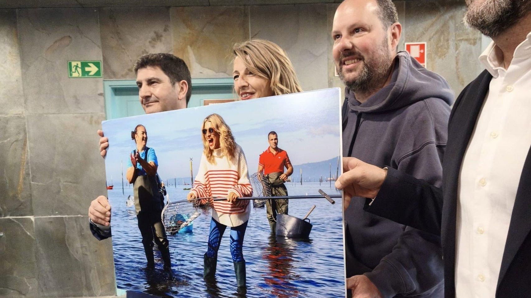 Momento en el que el fotógrafo Iñaki Abella le regala a Yolanda Díaz la foto que le hizo mariscando en Galicia.