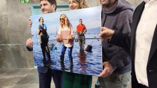 Momento en el que el fotógrafo Iñaki Abella le regala a Yolanda Díaz la foto que le hizo mariscando en Galicia.