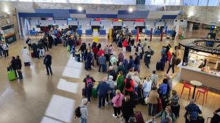 Vista de la terminal de Alvedro con pasajeros en colas de facturación.