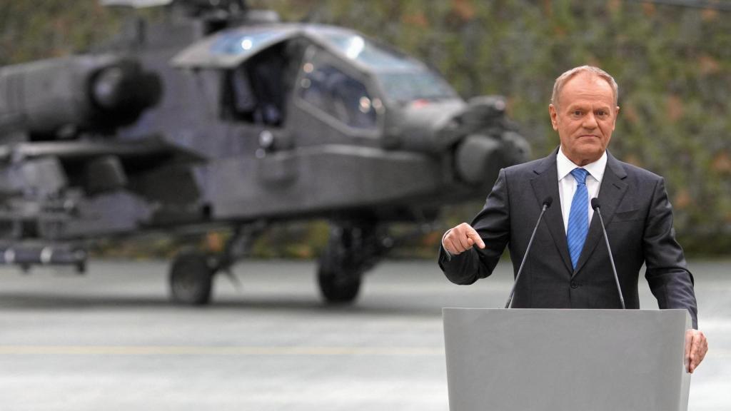 Prime Minister Donald Tusk before an Apache attack helicopter.