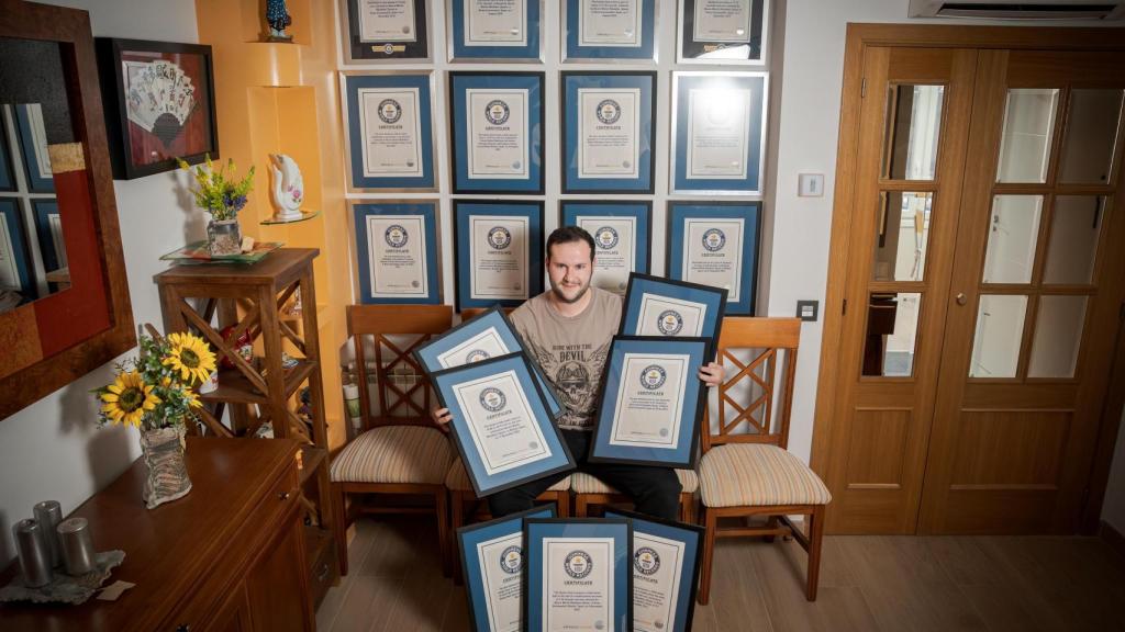 Álvaro Martín junto a su pared llena de Récords Guinness