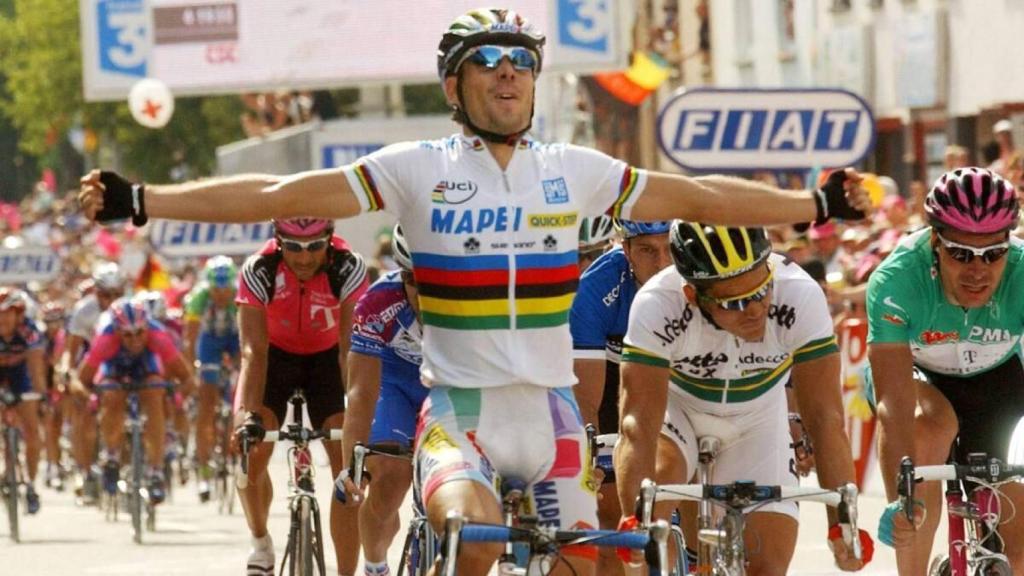 Óscar Freire, al término de una carrera, leyendo el maillot arcoíris.