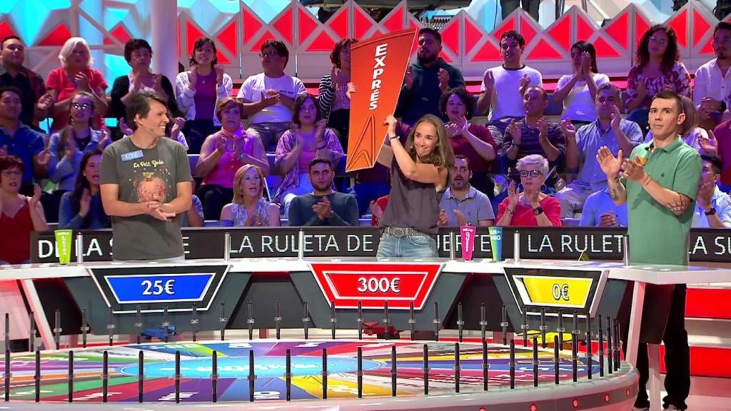 Una concursante levanta un gajo de 'La ruleta de la suerte'.