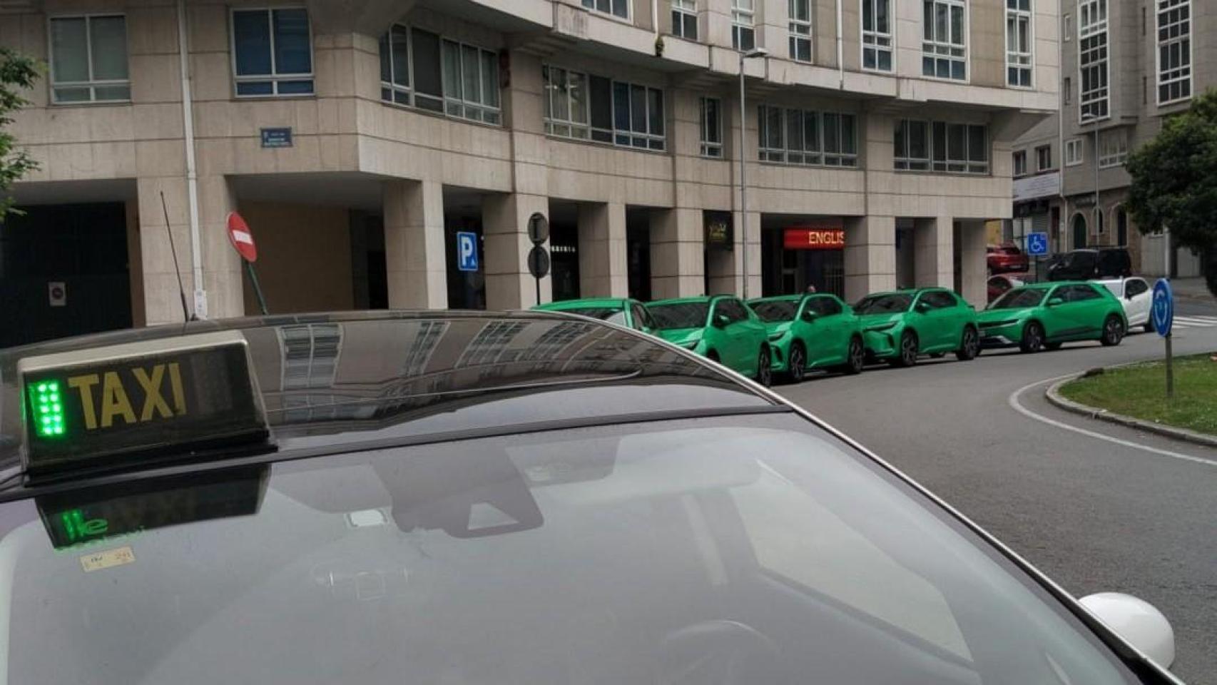 Un taxi en su parada, ante una flota de VTC en A Coruña.